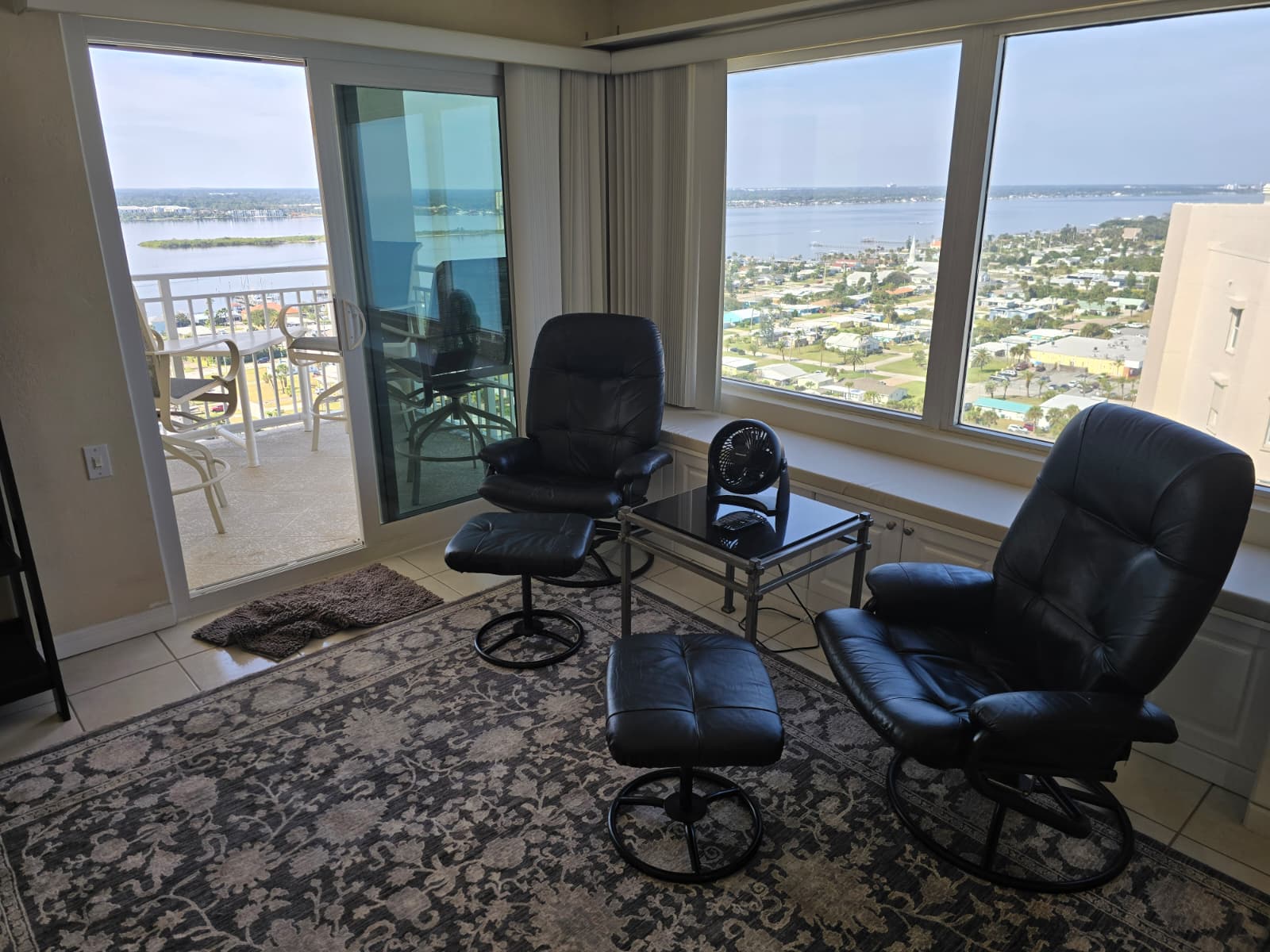 Living area opposite the office desk The area has a private river view balcony and queen pull-out sofa with sheets and pillows for 2-people