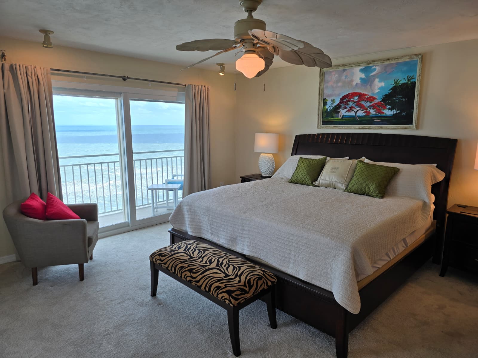 Oceanfront bedroom 1 with private balcony access The room has a king-size bed, sitting area and ensuite full bathroom